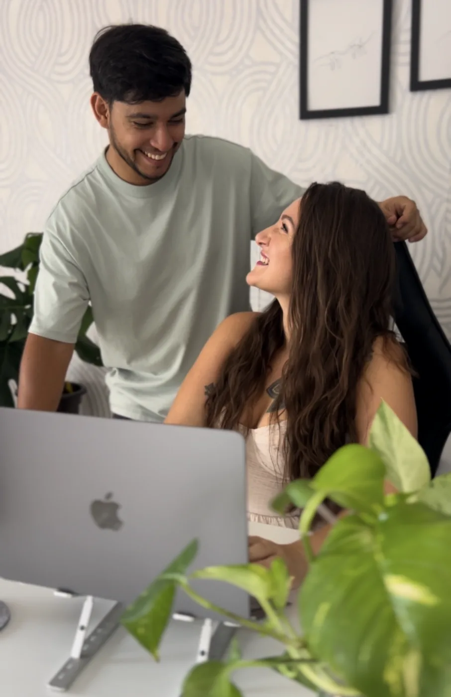 Elsi and Dio working together at a laptop